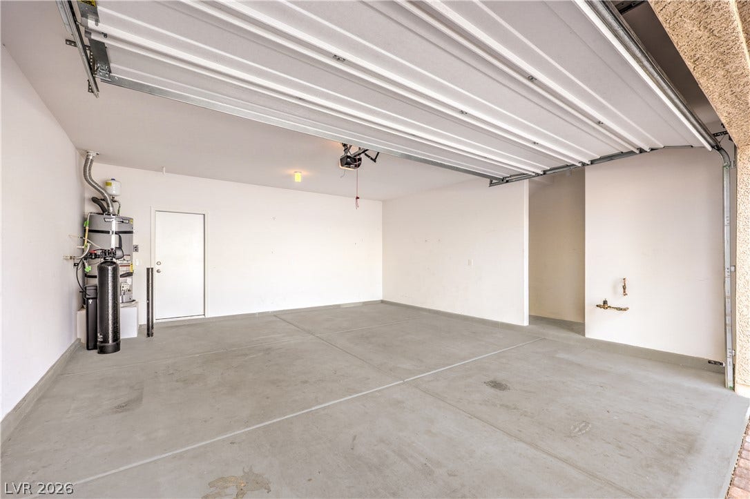 6934 Denio Island Street, North Las Vegas, NV 89084 A spacious garage with extra storage area features durable concrete flooring and direct interior access