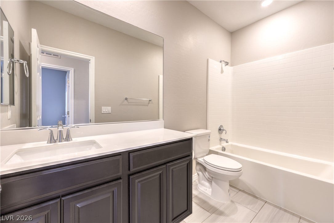 6934 Denio Island Street, North Las Vegas, NV 89084 Crisp subway tile surrounds the soaking tub in this modern Hall bathroom with neutral finishes.
