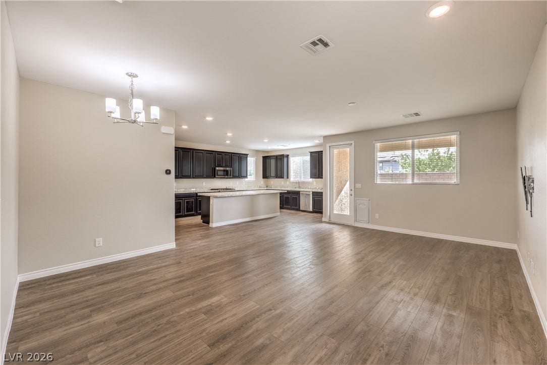 6934 Denio Island Street, North Las Vegas, NV 89084 A spacious open-plan layout connects the main living areas over durable wood-look flooring.