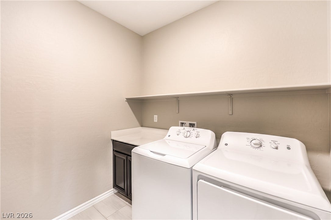 6934 Denio Island Street, North Las Vegas, NV 89084 An organized utility space features overhead shelving and tile flooring alongside laundry connections.