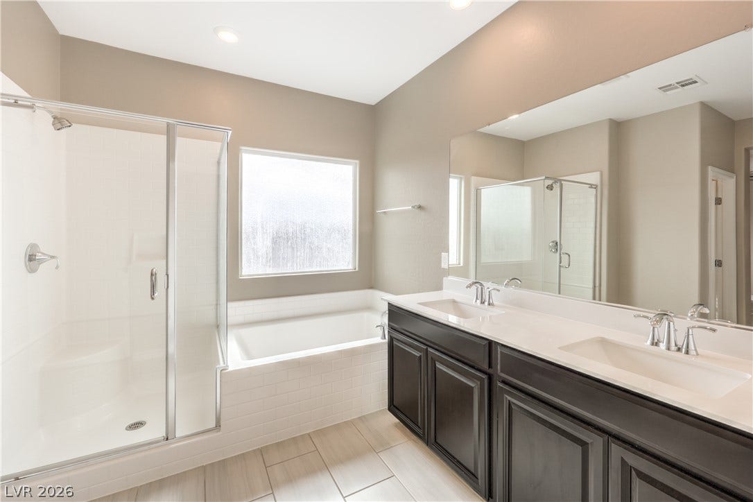 6934 Denio Island Street, North Las Vegas, NV 89084 Clean lines and a spacious dual vanity highlight this contemporary master bathroom retreat.