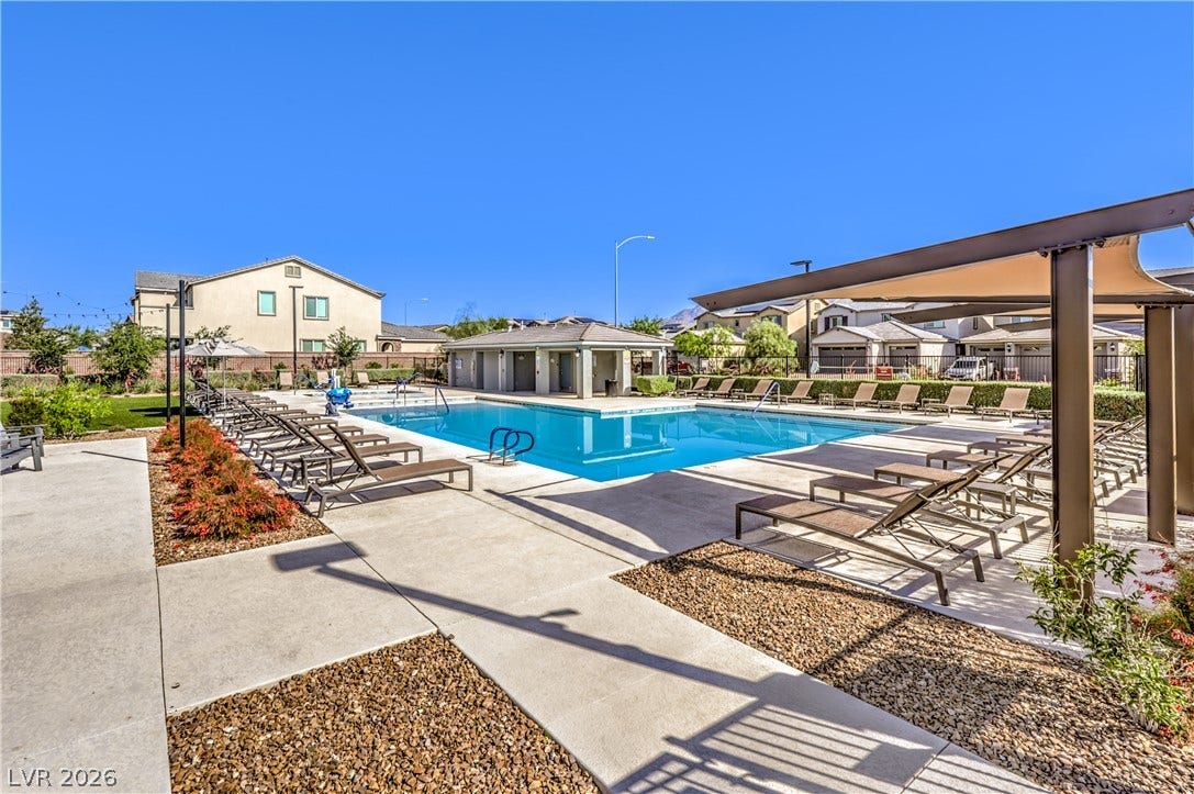 6934 Denio Island Street, North Las Vegas, NV 89084 Sun-drenched concrete decking surrounds a large community swimming pool under clear blue skies.