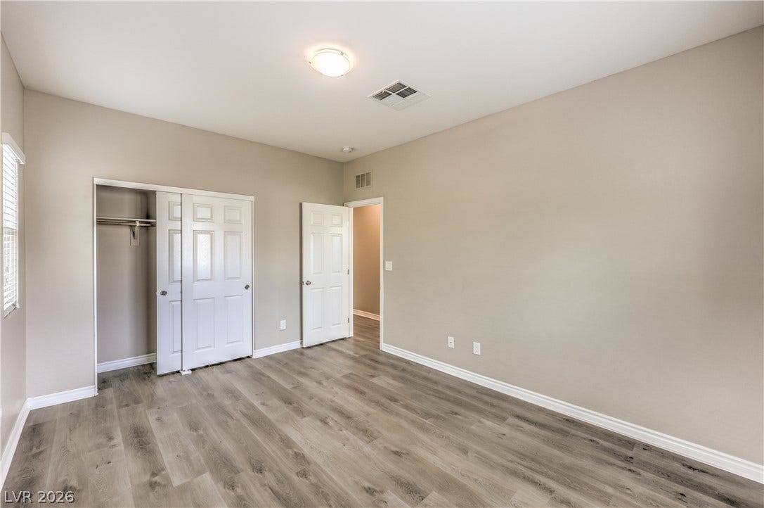 6934 Denio Island Street, North Las Vegas, NV 89084 Gleaming wood-look floors and clean trim define this versatile secondary bedroom space.