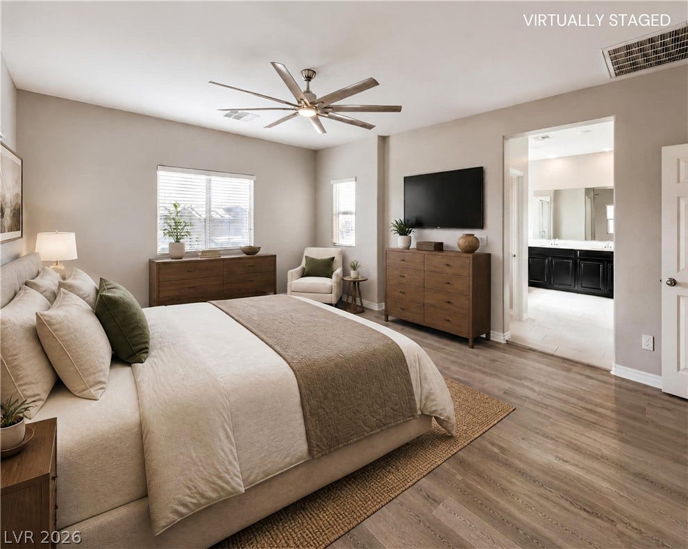 6934 Denio Island Street, North Las Vegas, NV 89084 Smooth wood-plank flooring runs throughout this main bedroom suite leading into an attached bath.