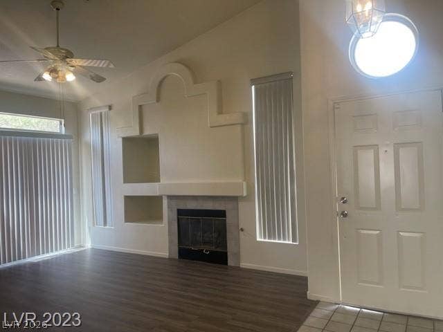 A spacious living room features wood-look flooring and a prominent fireplace with architectural built-ins.