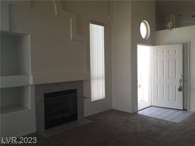Soaring ceilings and a tiled fireplace define this welcoming entryway and living space.