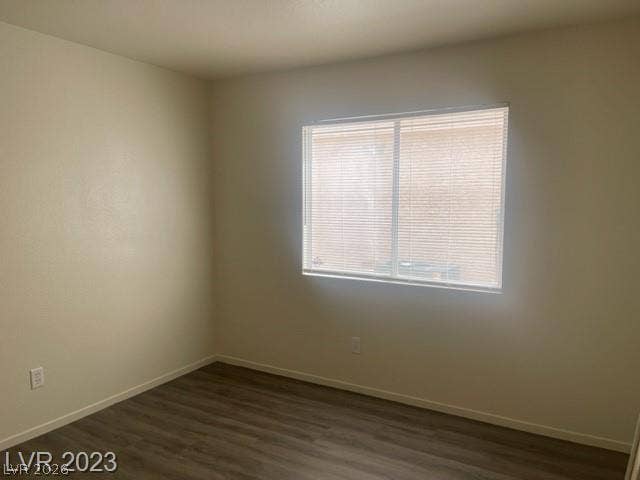 Smooth wood-look flooring and a wide window with blinds define this versatile room.