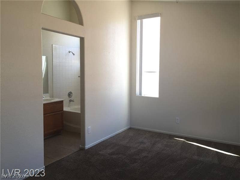 High ceilings and tall windows enhance this comfortable bedroom suite with an attached bath.