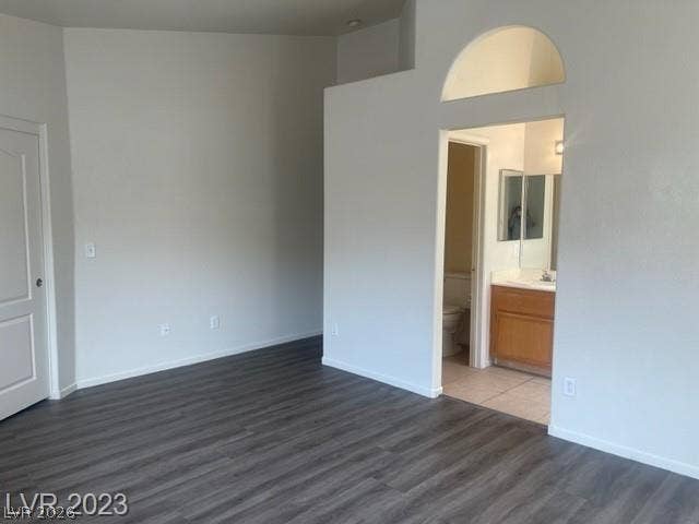 High ceilings and low-maintenance wood-look flooring enhance this primary bedroom suite with attached bath.
