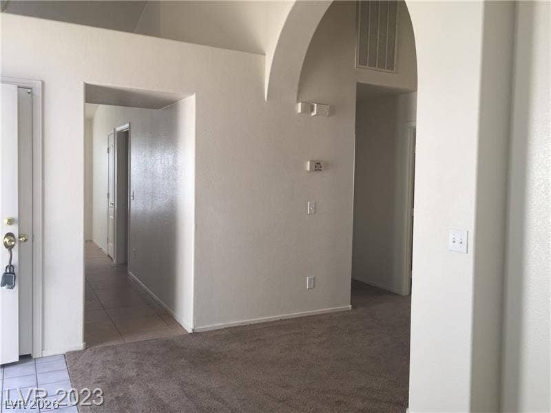 High ceilings and an arched doorway highlight this transitions-rich living space.