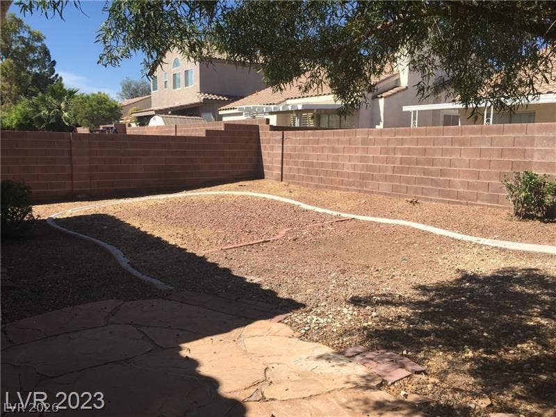 A spacious block-walled backyard provides a private outdoor retreat with a flagstone patio area.