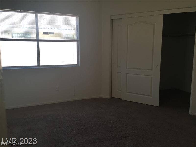 Natural light fills this bedroom complete with soft carpeting and sliding closet doors.