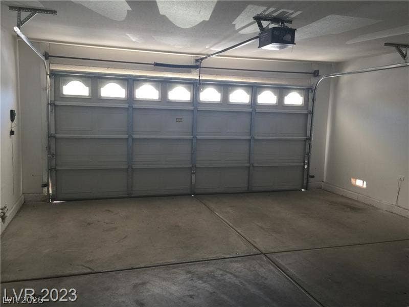 A spacious garage features durable concrete flooring and an automatic overhead door with integrated windows.