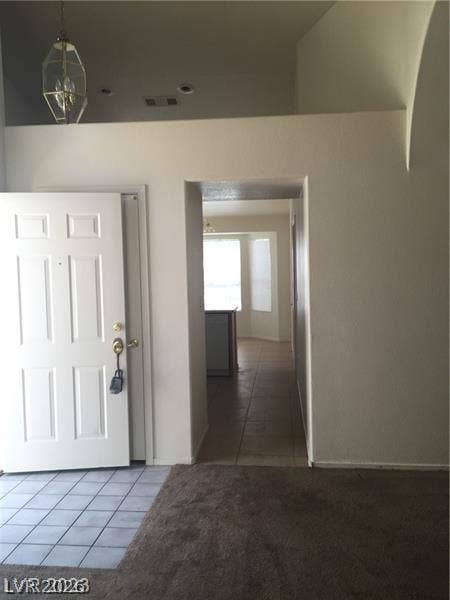 High ceilings and an open doorway frame the welcoming entryway of this home.