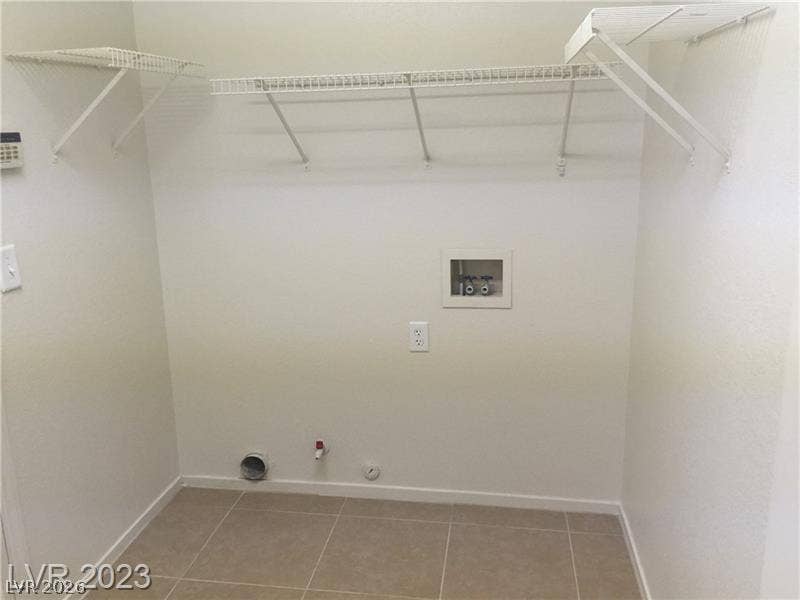 Tiled flooring and convenient overhead wire shelving maximize utility in this dedicated laundry space.