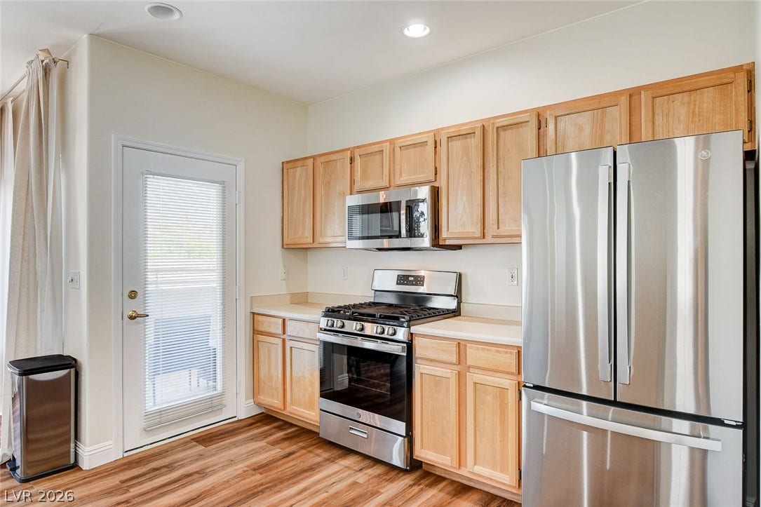 1520 Ruby Cliffs Lane, #203, Las Vegas, NV 89144 Natural wood cabinetry and stainless steel appliances anchor this bright kitchen space with durable flooring.