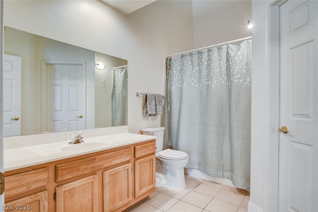 1520 Ruby Cliffs Lane, #203, Las Vegas, NV 89144 High ceilings and neutral tile flooring complement this functional vanity setup.