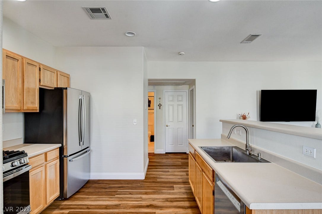 1520 Ruby Cliffs Lane, #203, Las Vegas, NV 89144 Rich wood flooring grounds this modern kitchen, which flows seamlessly into neighboring living spaces.