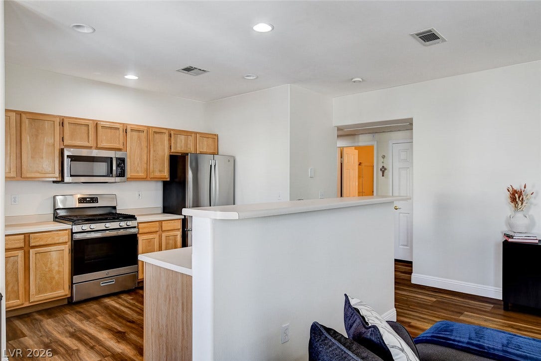 1520 Ruby Cliffs Lane, #203, Las Vegas, NV 89144 Rich wood flooring complements honey-toned cabinetry in this thoughtfully arranged culinary space.