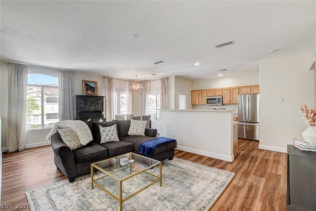 1520 Ruby Cliffs Lane, #203, Las Vegas, NV 89144 Rich wood-look flooring and an open layout connect the relaxed living space and kitchen.