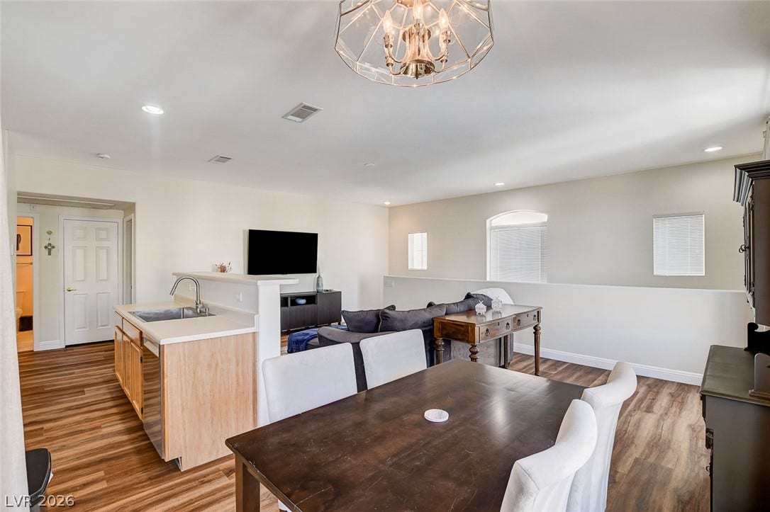 1520 Ruby Cliffs Lane, #203, Las Vegas, NV 89144 Warm wood flooring grounds this open-concept layout connecting the kitchen and dining areas.