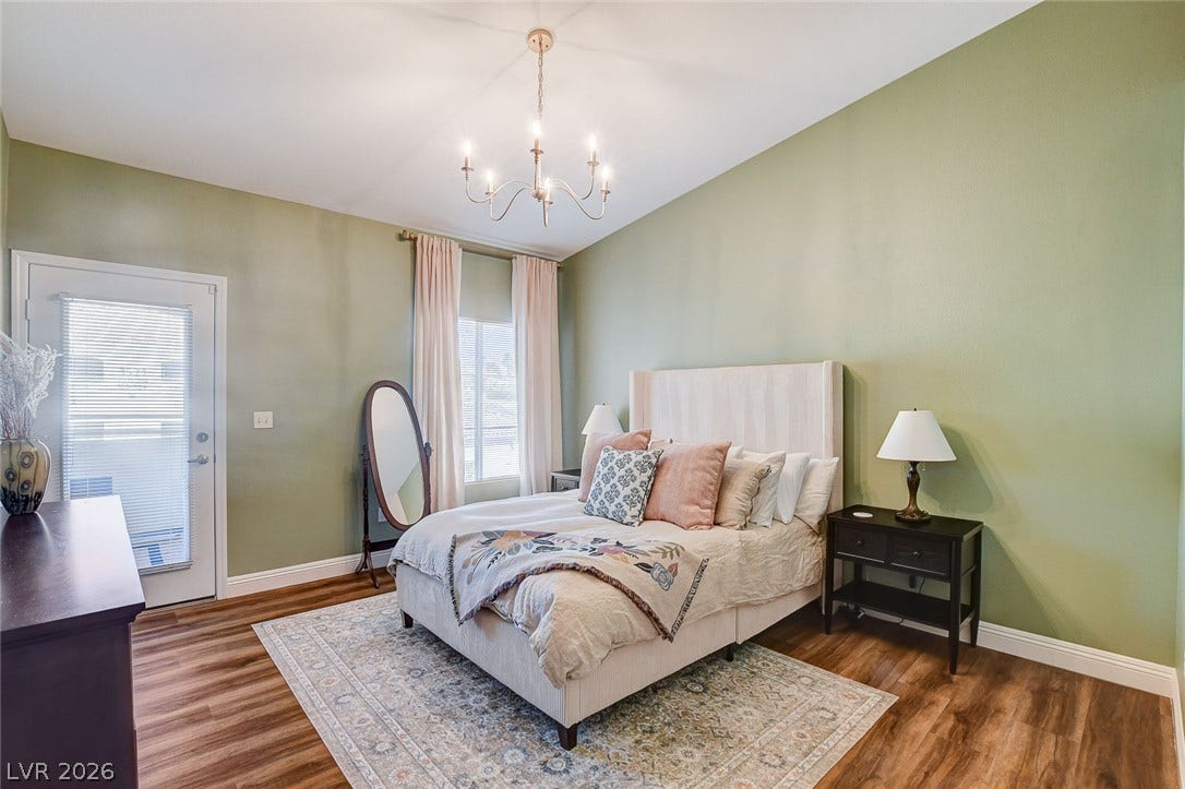 1520 Ruby Cliffs Lane, #203, Las Vegas, NV 89144 Soaring ceilings and rich wood floors anchor this serene primary bedroom retreat.
