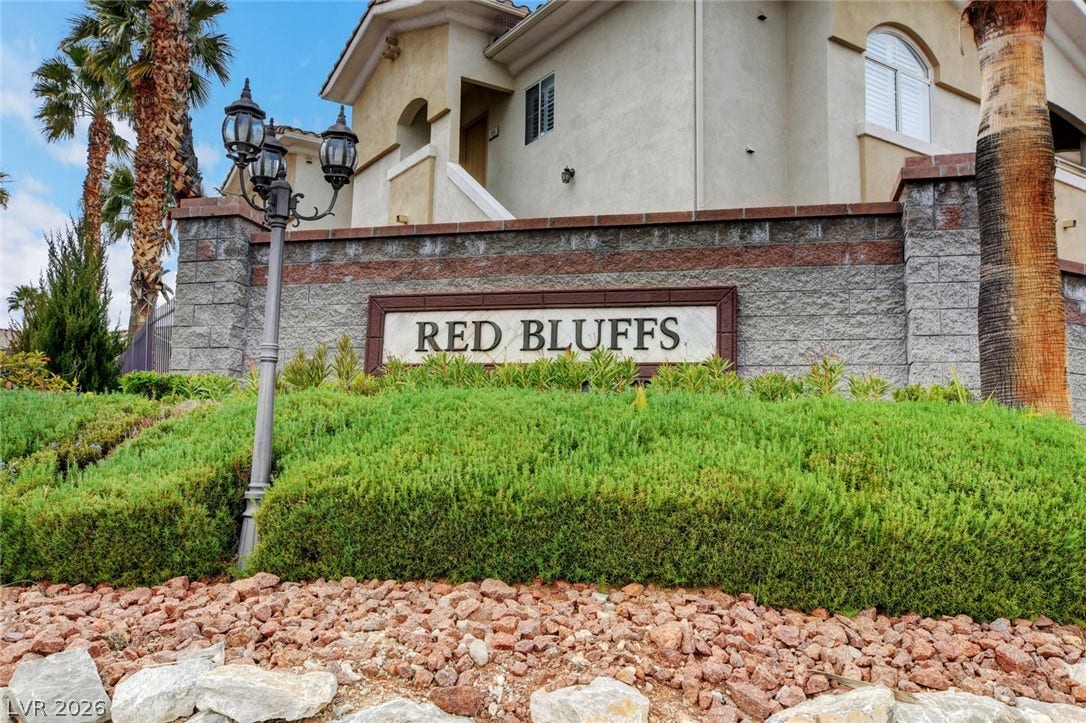1520 Ruby Cliffs Lane, #203, Las Vegas, NV 89144 Welcoming community signage framed by neat landscaping and desert-inspired stone ground cover.