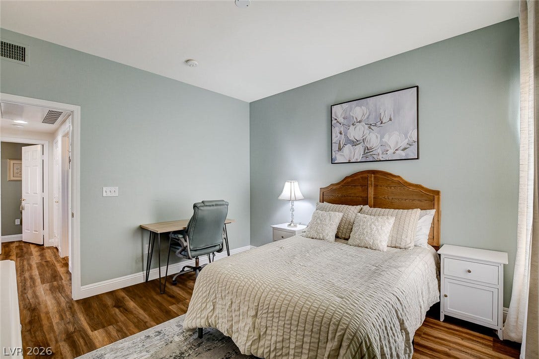 1520 Ruby Cliffs Lane, #203, Las Vegas, NV 89144 Gleaming wood floors anchor this comfortable bedroom workspace setup.