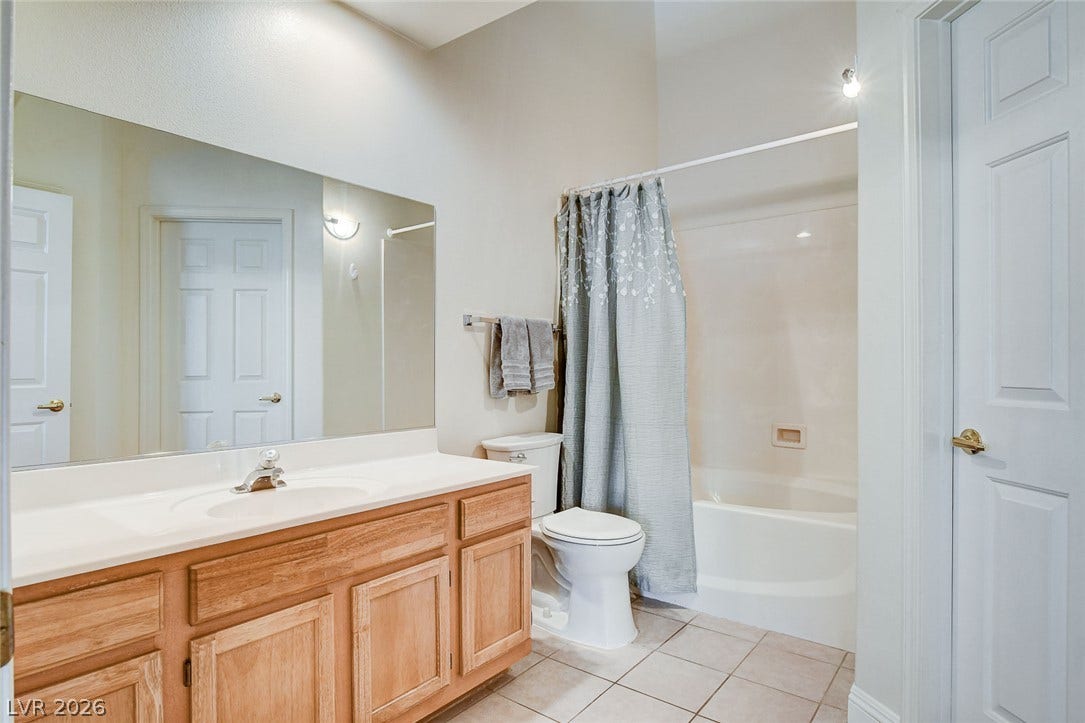 1520 Ruby Cliffs Lane, #203, Las Vegas, NV 89144 Tiled flooring and a wooden vanity define this classic secondary bath space.