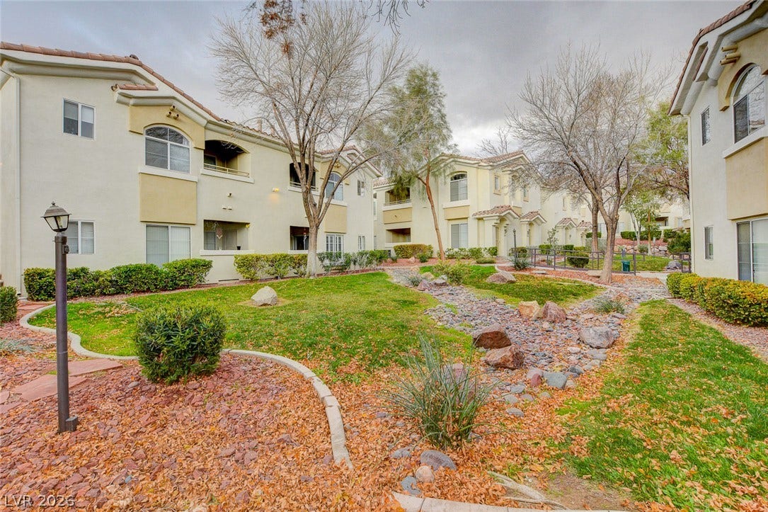 1520 Ruby Cliffs Lane, #203, Las Vegas, NV 89144 Manicured green spaces and stony paths weave throughout the stucco exterior of this multi-level community.