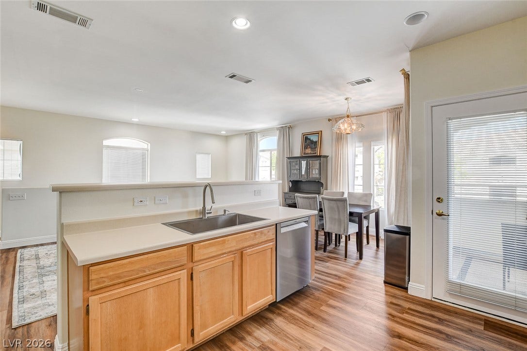1520 Ruby Cliffs Lane, #203, Las Vegas, NV 89144 Polished wood-style flooring pairs with recessed lighting to connect the kitchen and dining zones.