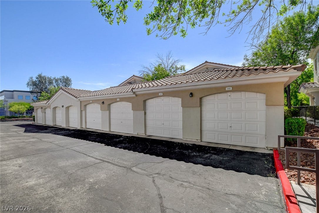 1520 Ruby Cliffs Lane, #203, Las Vegas, NV 89144 Multi-car garage bays feature individual overhead doors set beneath a classic Spanish tile roof.