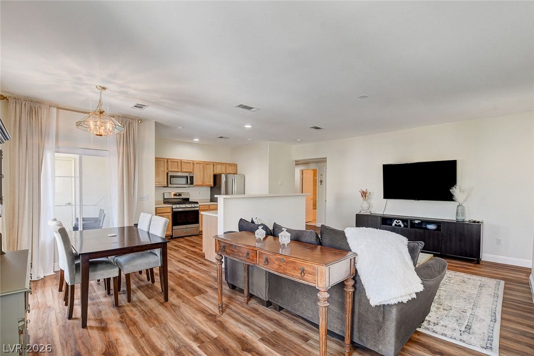 1520 Ruby Cliffs Lane, #203, Las Vegas, NV 89144 Gleaming wood-look floors anchor a versatile, open-concept living area with integrated kitchen and dining spaces.