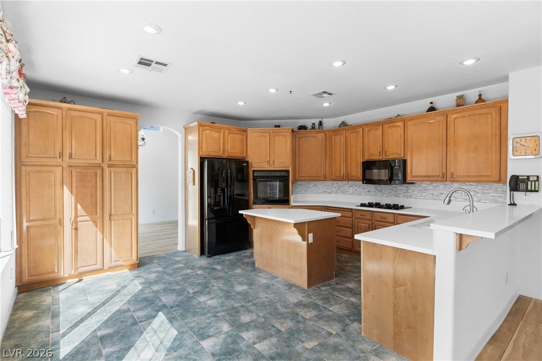 Culinary aspirations come alive in this kitchen featuring abundant cabinetry and sleek white countertops.