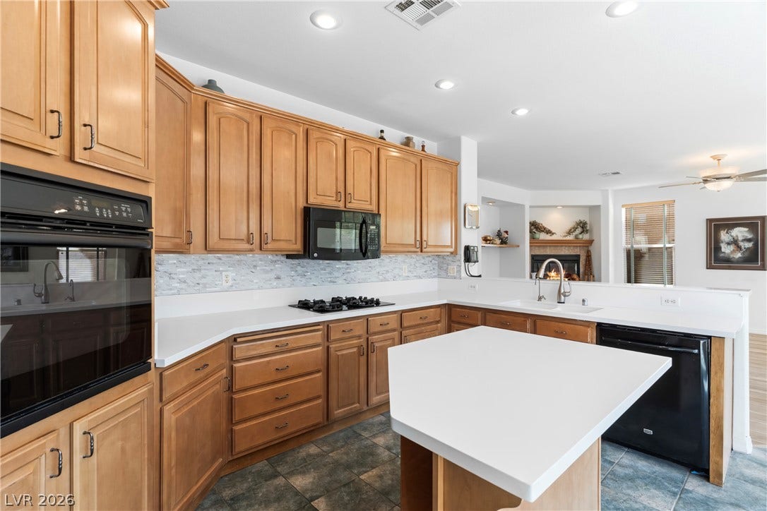 Culinary adventures await in this kitchen, featuring light wood cabinetry and contrasting white countertops.
