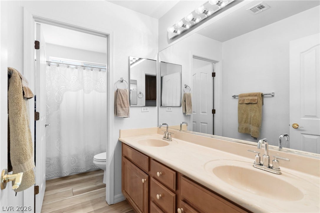 Double vanity sinks and bright lighting enhance this functional bathroom's appeal.
