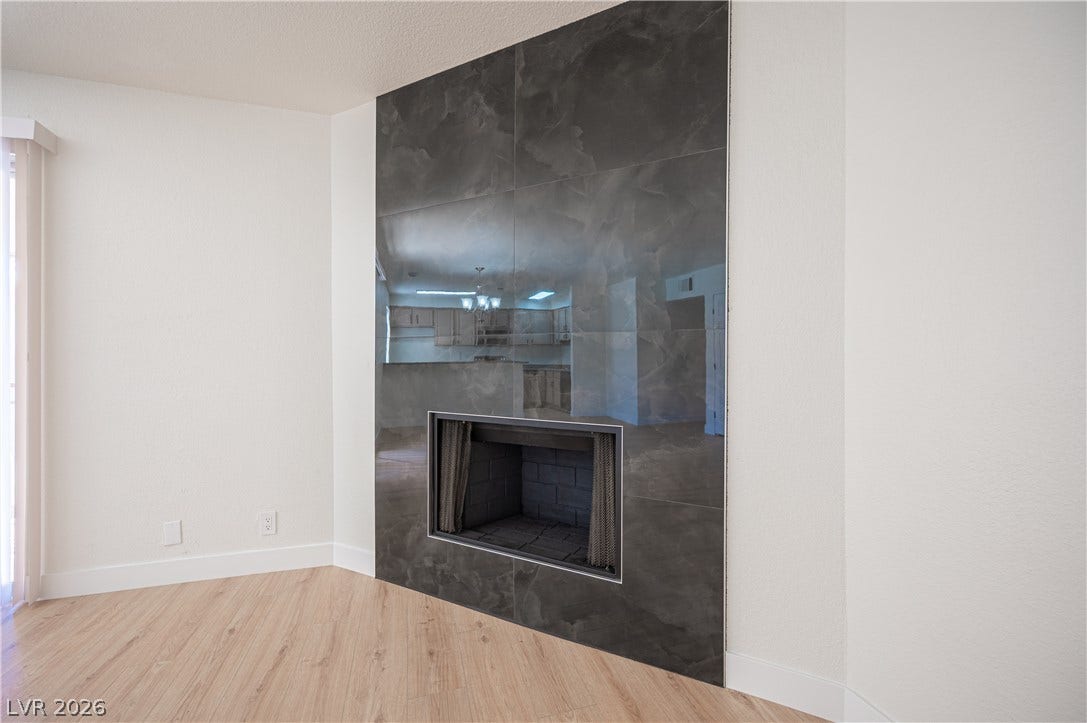 4381 Alexis Drive, #332, Las Vegas, NV 89103 Warm wood flooring complements a floor-to-ceiling tiled fireplace surround.
