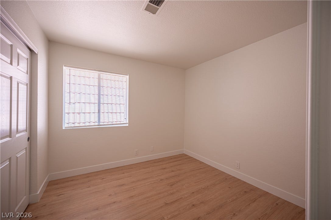 4381 Alexis Drive, #332, Las Vegas, NV 89103 Crisp white walls and warm wood-style flooring create a clean slate in this versatile bedroom.