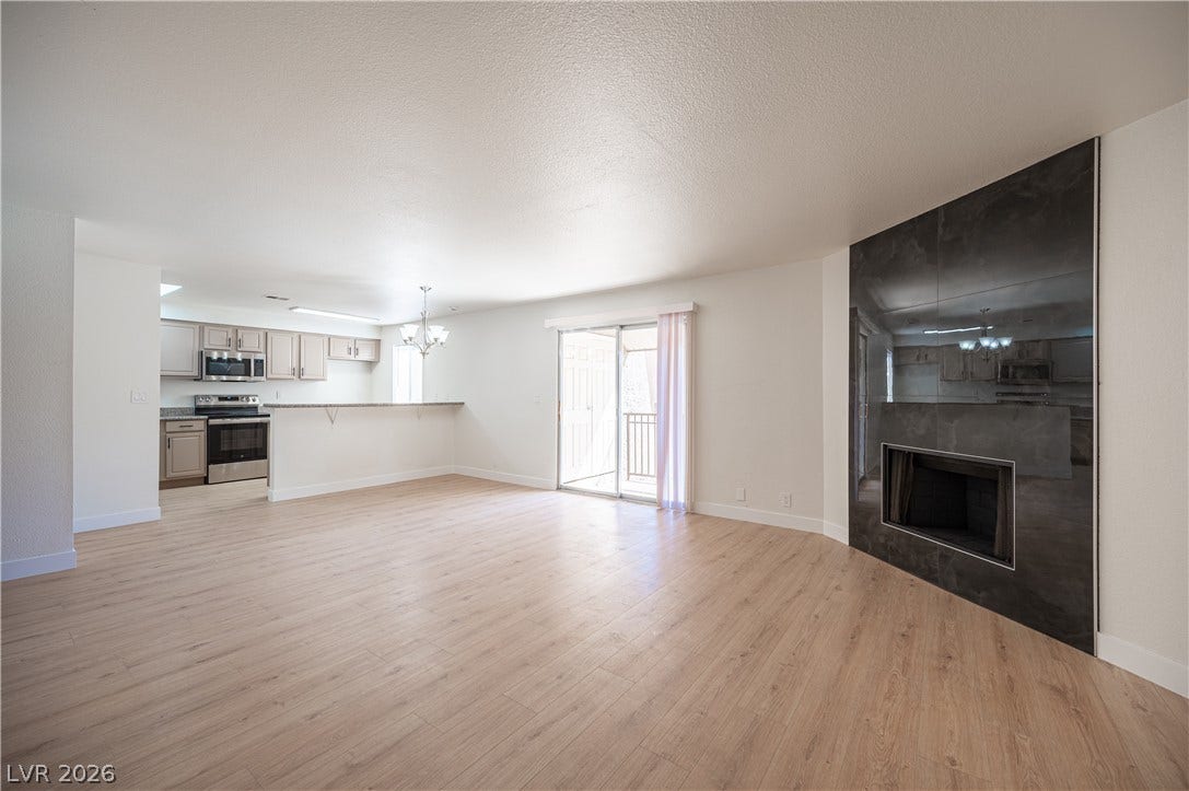 4381 Alexis Drive, #332, Las Vegas, NV 89103 An open layout connects the living area with a sleek fireplace to the kitchen.