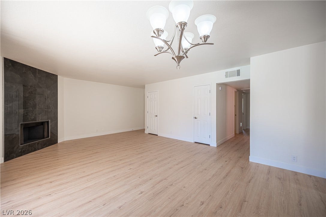4381 Alexis Drive, #332, Las Vegas, NV 89103 Smooth wood floors anchor this open space featuring a modern tiled fireplace wall.