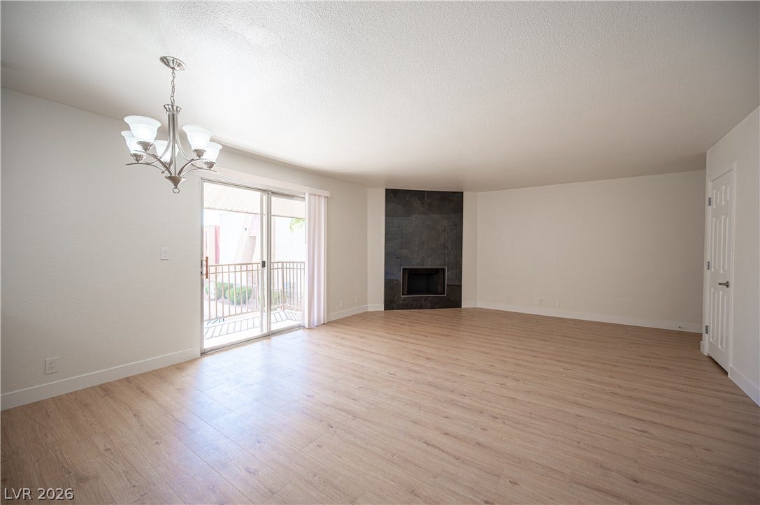 4381 Alexis Drive, #332, Las Vegas, NV 89103 Hardwood floors and a corner fireplace anchor this light-filled living area opening to a balcony.