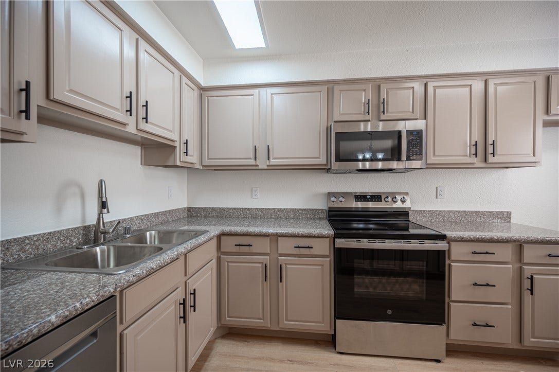 4381 Alexis Drive, #332, Las Vegas, NV 89103 Ample cabinetry, speckled stone counters, and modern stainless appliances define this functional kitchen.