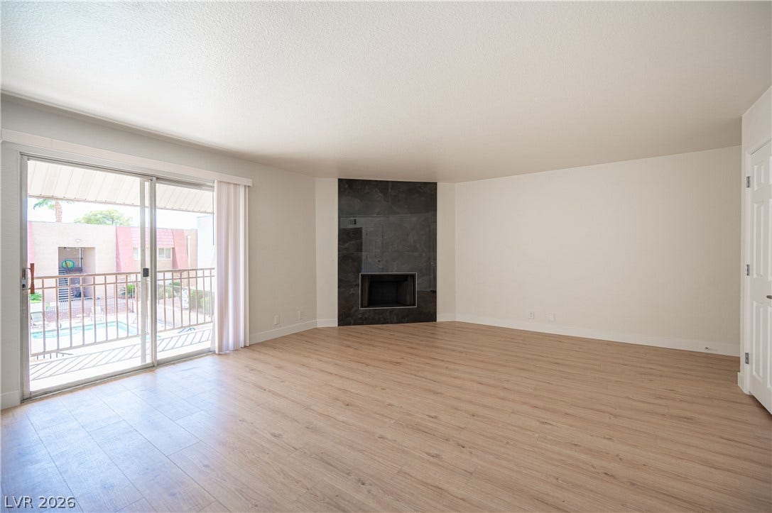 4381 Alexis Drive, #332, Las Vegas, NV 89103 Warm wood flooring and a modern fireplace anchor this bright, open living space.
