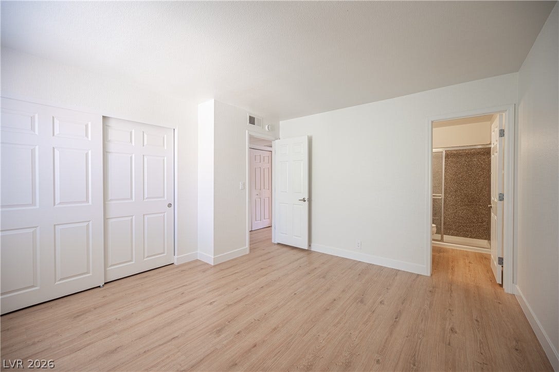 4381 Alexis Drive, #332, Las Vegas, NV 89103 Smooth wood floors flow seamlessly through this light-filled bedroom with private ensuite bathroom access.
