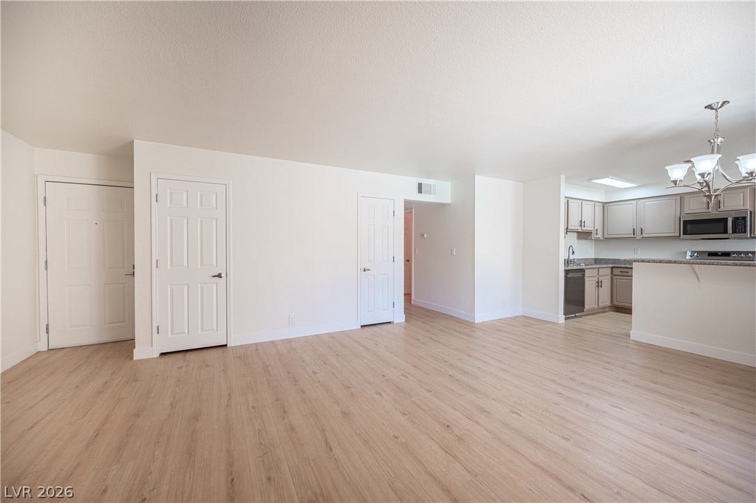 4381 Alexis Drive, #332, Las Vegas, NV 89103 Light wood floors complement the neutral walls in this open living area with kitchen access.