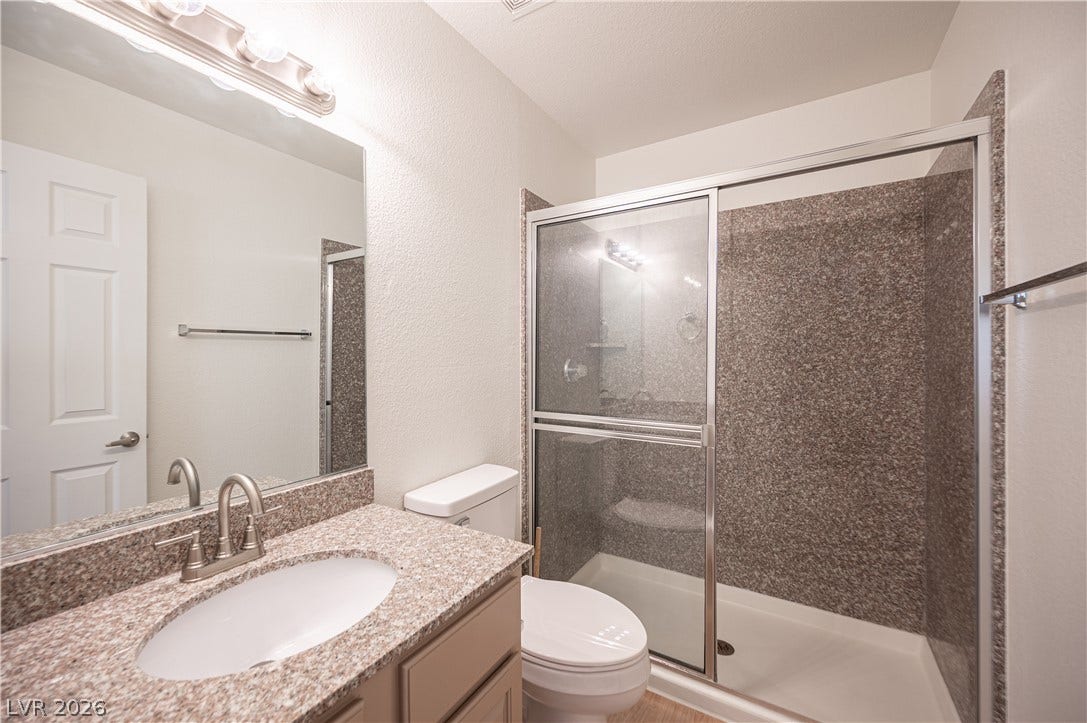 4381 Alexis Drive, #332, Las Vegas, NV 89103 Polished stone counters and a glass-enclosed walk-in shower elevate this functional bathroom.