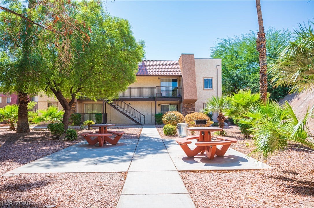 4381 Alexis Drive, #332, Las Vegas, NV 89103 A paved walkway winds through a landscaped common area with mature trees and picnic tables.
