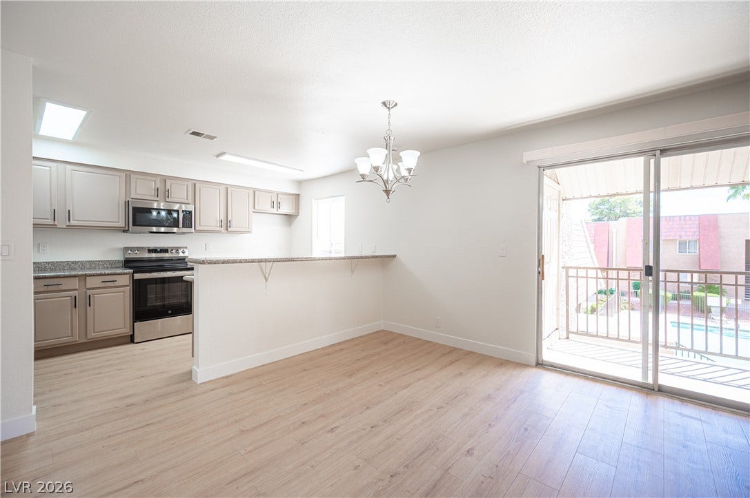 4381 Alexis Drive, #332, Las Vegas, NV 89103 Sliding glass doors open to a private balcony from this airy dining area and kitchen.