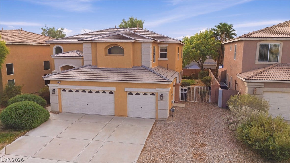4871 Lionesse Court, Las Vegas, NV 89130 Mediterranean-inspired stucco exterior with a tiled roofline and a spacious three-car garage.