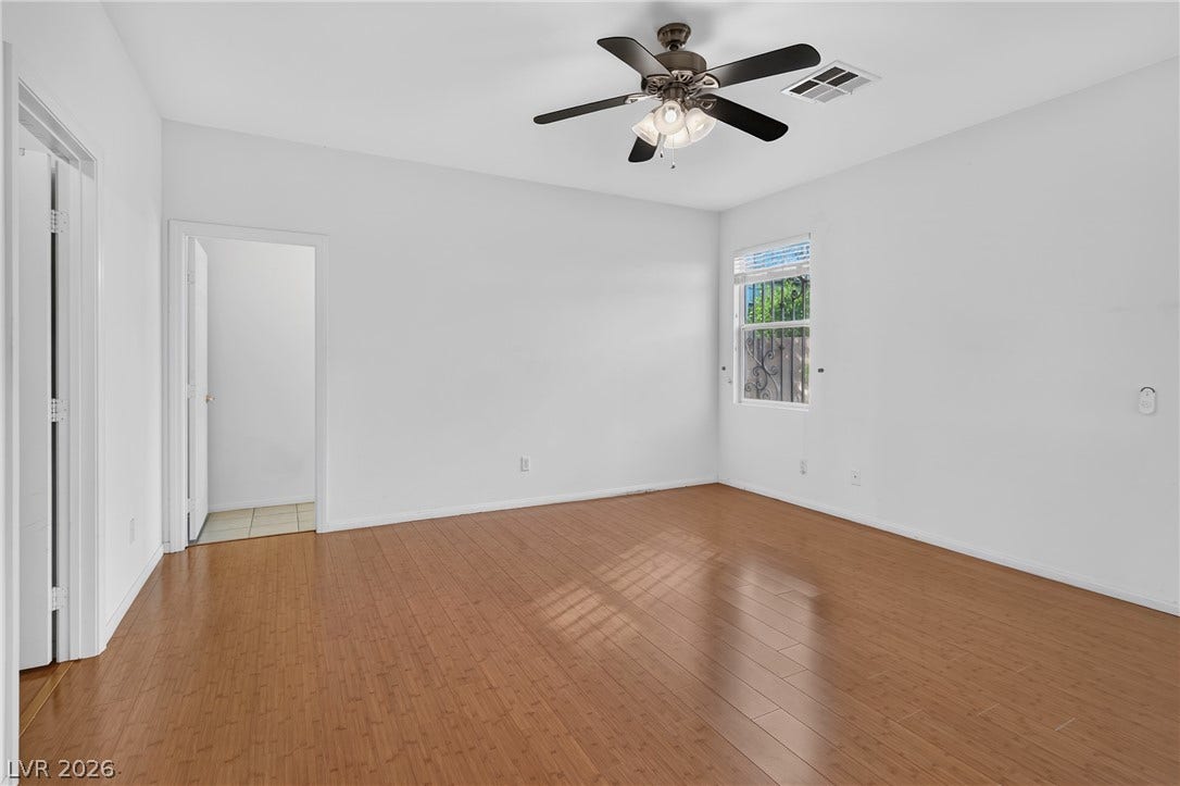 4871 Lionesse Court, Las Vegas, NV 89130 Gleaming hardwood floors run throughout this spacious bedroom with a neutral palette.
